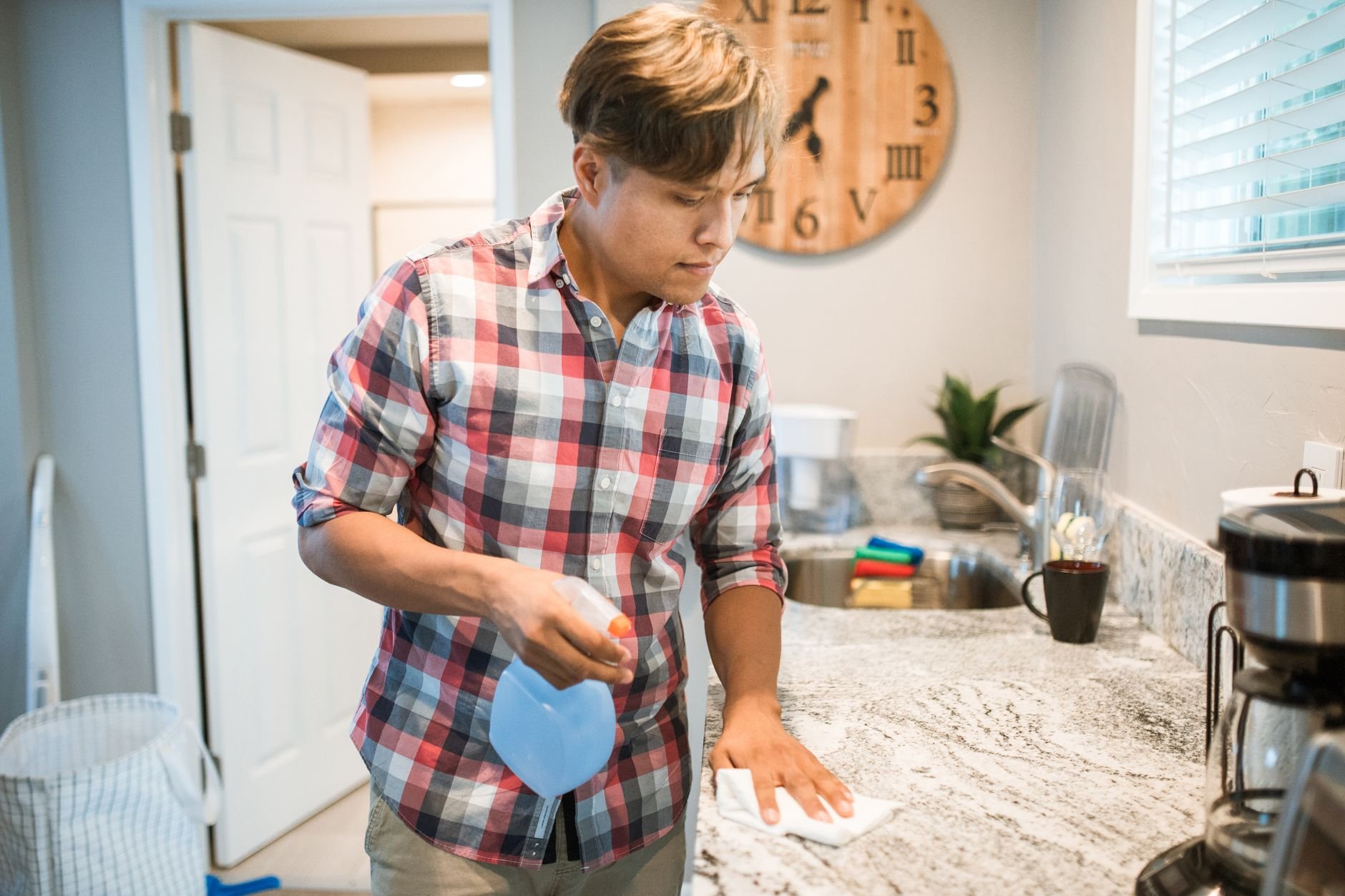 Professional cleaning a kitchen counter in a rental unit